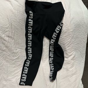Black gap leggings that has GAP embroidered in white on the side.